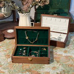 Wooden jewelry box with jewelry on a patterned surface