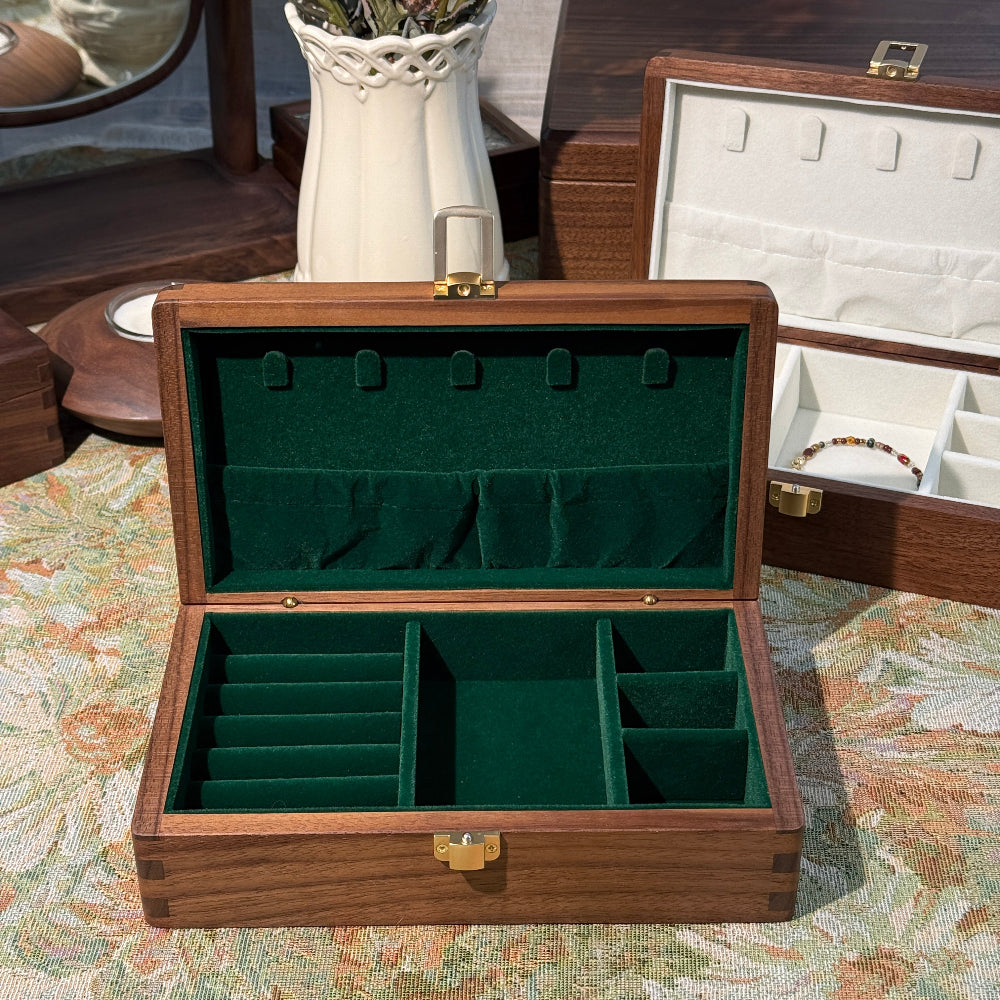 Wooden jewelry box with green interior on a floral-patterned surface